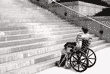 Una persona en silla de ruedas, que no puede subir unas escaleras.